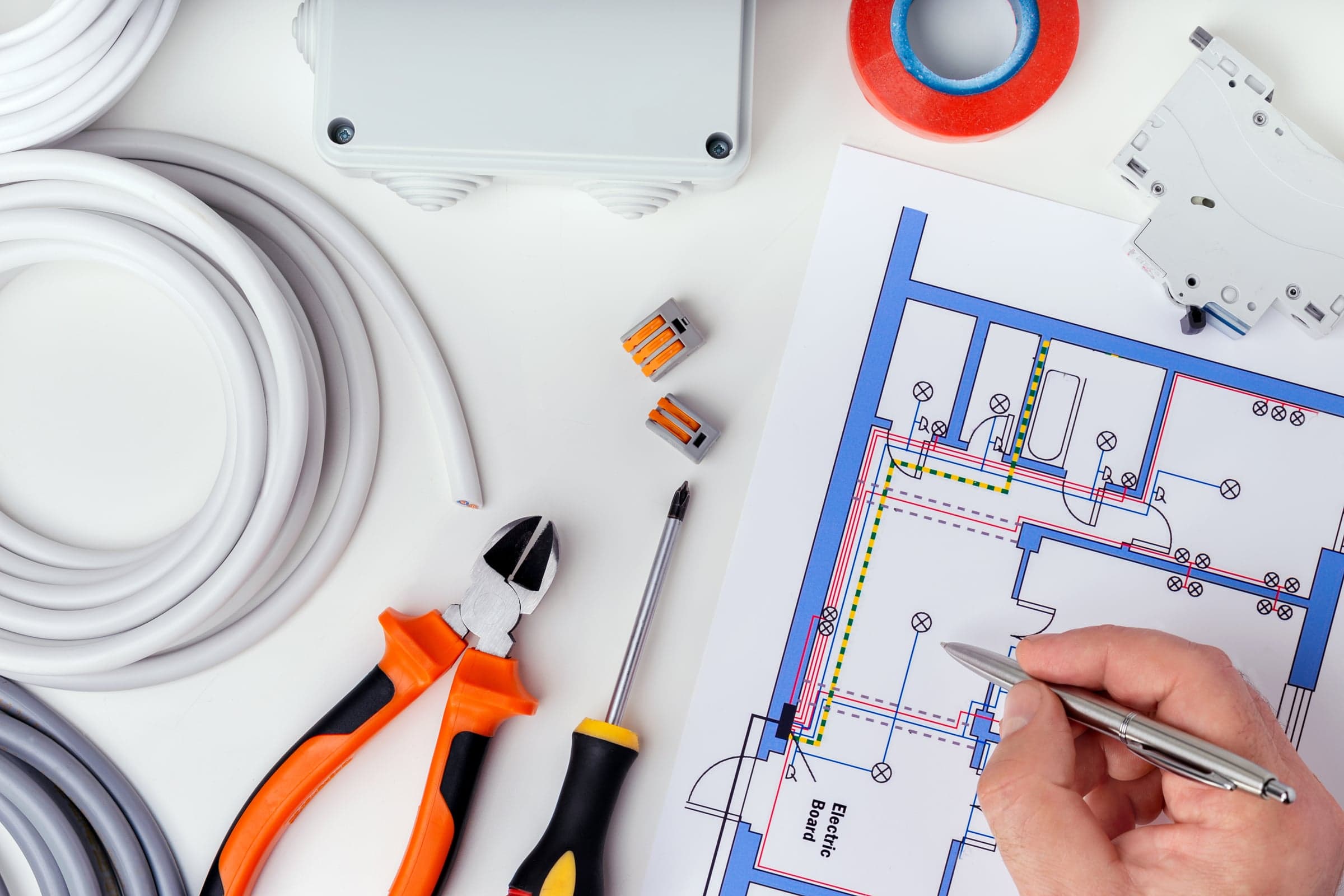 Electrical drawing showing cable routing, with cables, a junction box, terminal connectors, a miniature circuit breaker and tools beside it